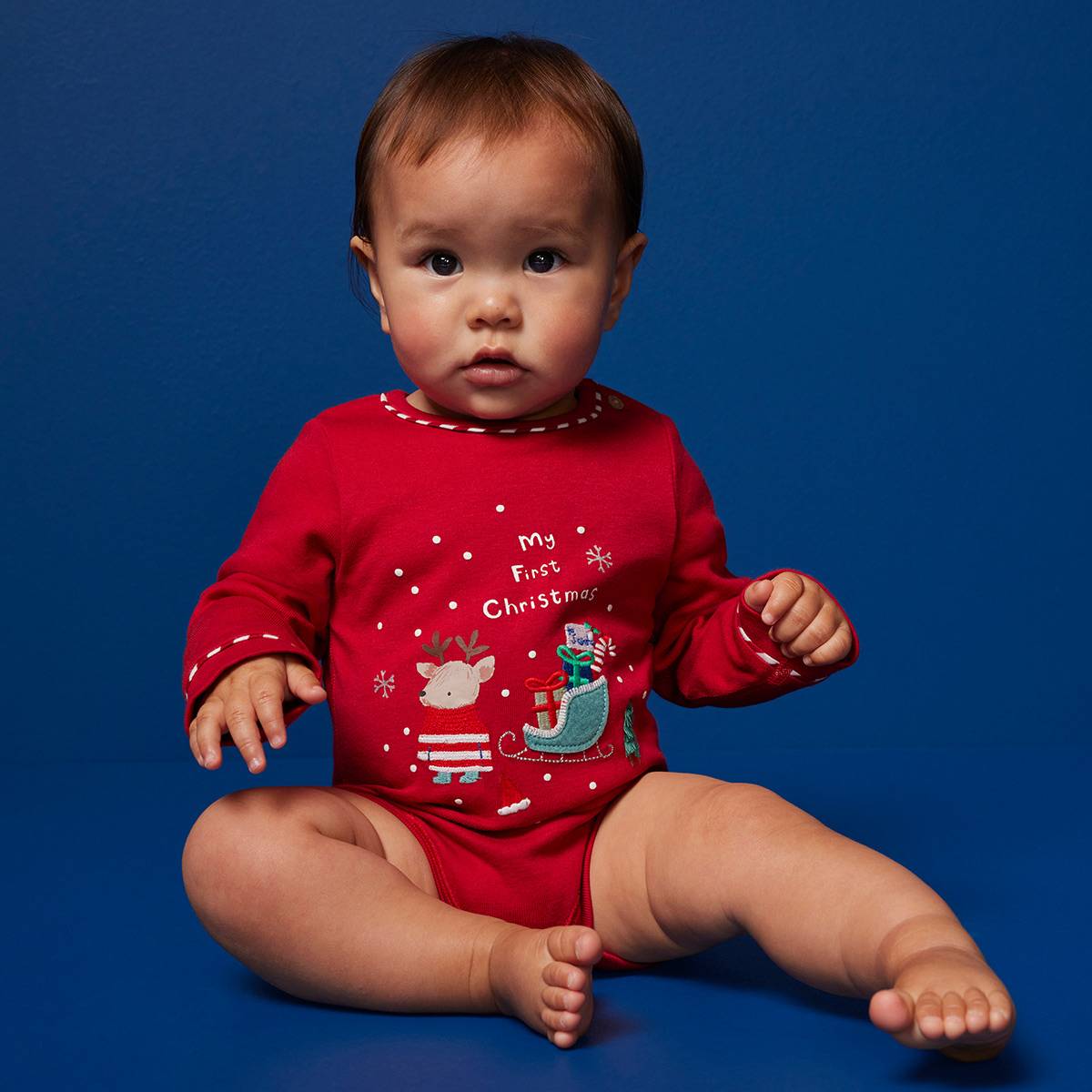 Baby wearing red bodysuit. Shop baby gifts